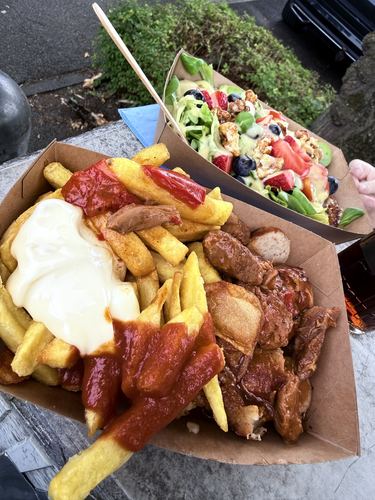 Zwei Foodtruck-Boxen mit Currywurst-Pommes und frischem Salat
